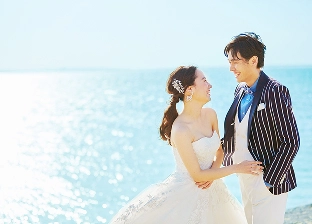 きれいな海を背景に見つめ合う新郎新婦