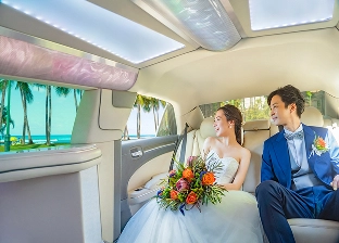 車の中からリゾート地を眺める新郎新婦