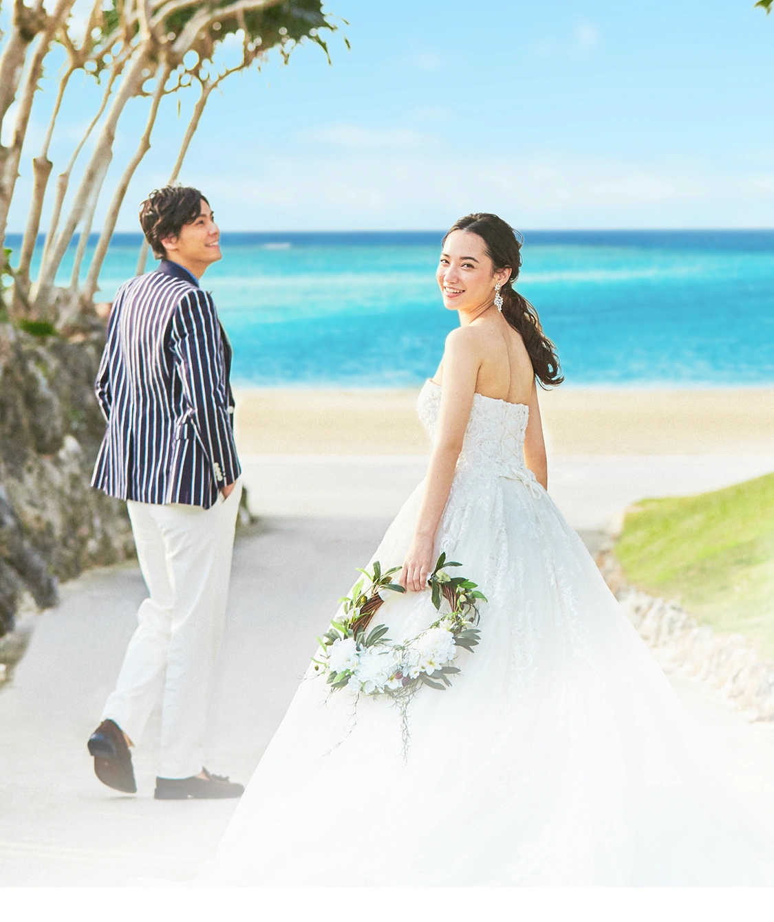 ビーチで手をつなぐ新郎新婦