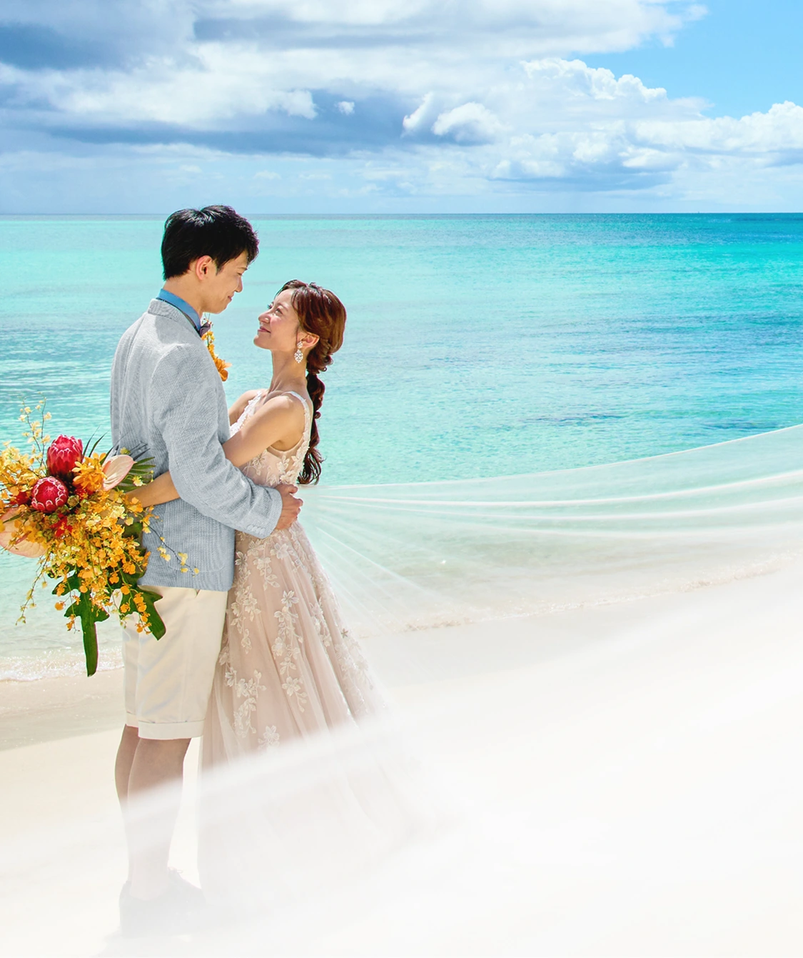 ビーチで手をつなぐ新郎新婦